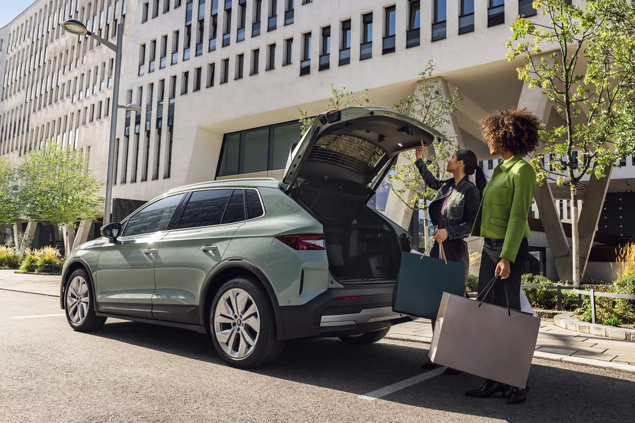 Dos chicas cargando bolsas en el maletero de un coche de alquiler del Grupo Volkswagen
