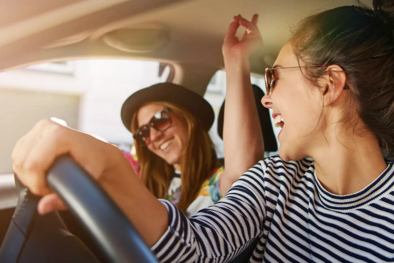 Chicas sonriendo dentro de un coche de Financiación NEXT