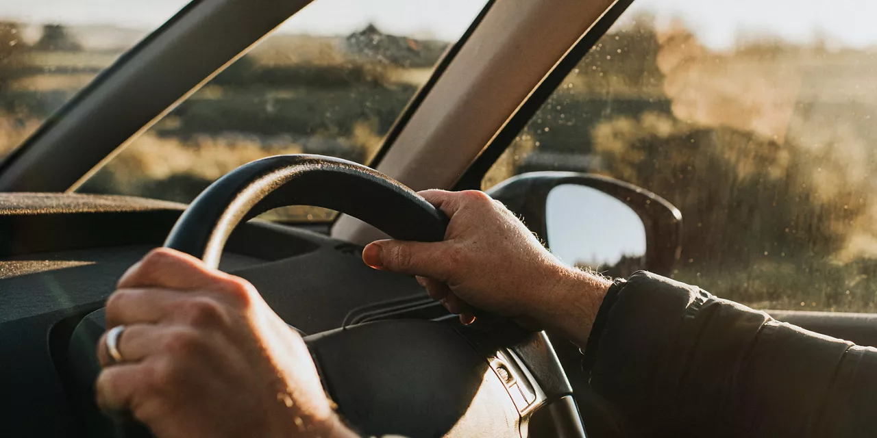 Detalle de manos al volante de un coche con Long Drive Service